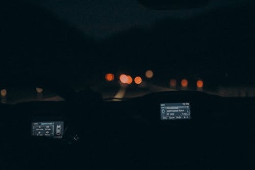 A car driving at night with the headlights on