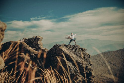 A person standing on top of a rock in the mountains