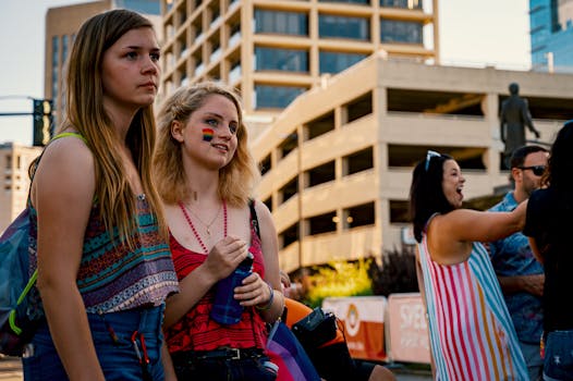 两名年轻女性在城市建筑的背景下参加户外骄傲节