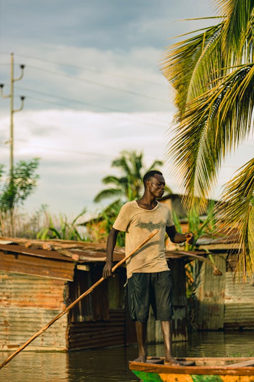 A man standing on a boat in a flooded area