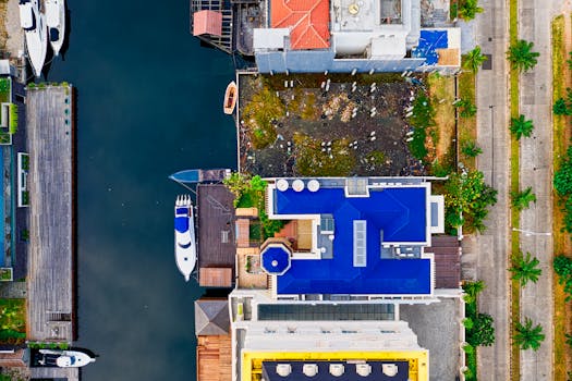 Aerial photo showcasing waterfront buildings, boats, and greenery in an urban setting.