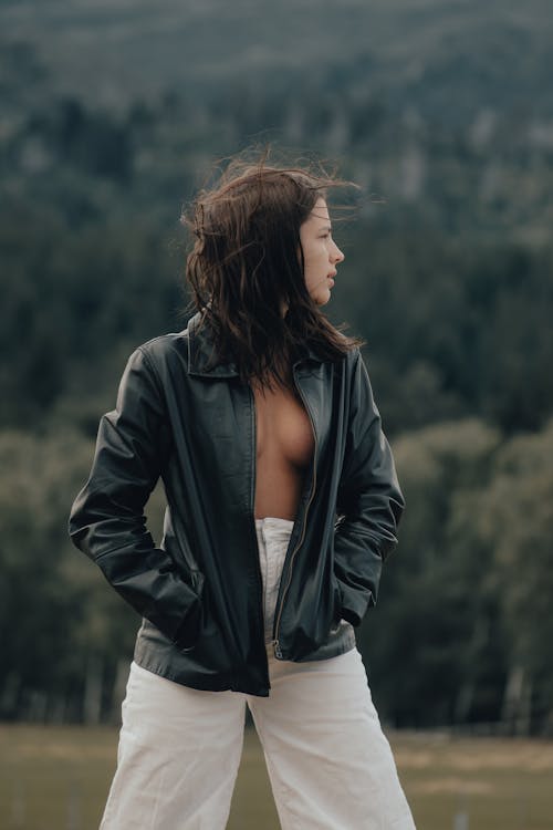 A woman in white pants and a leather jacket