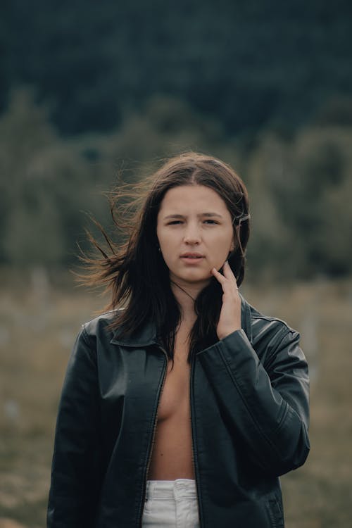 A woman in a leather jacket standing in a field