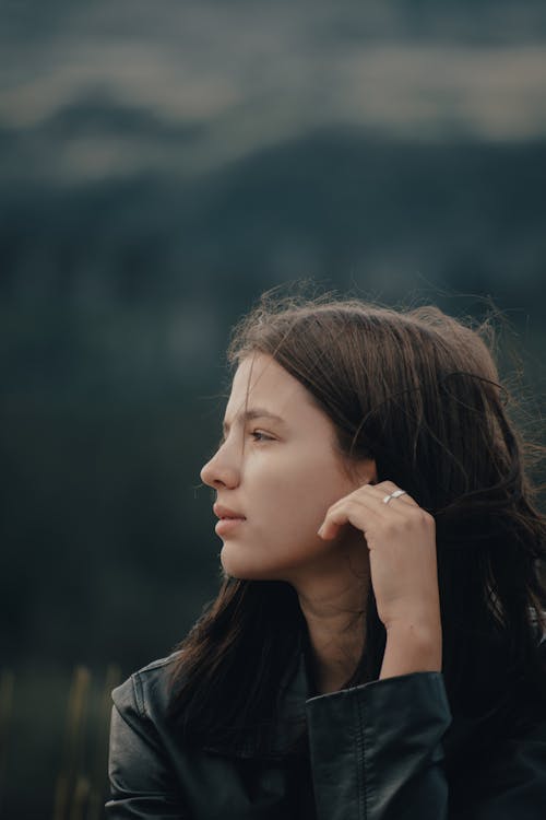 Free A woman with her hand on her chin looking out into the distance Stock Photo