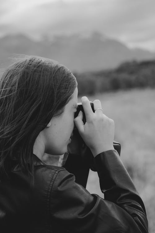 A woman taking a photo of a mountain range