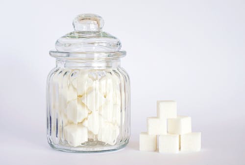 Close-Up Photo of Sugar Cubes in Glass Jar