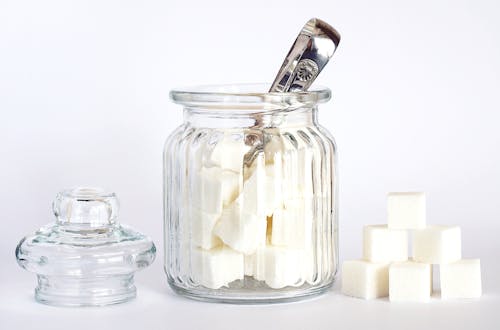 Close-Up Photo of Sugar Cubes in Glass Jar