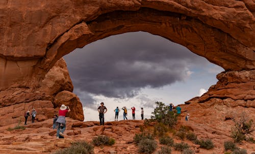 A group of people standing in front of a large arch