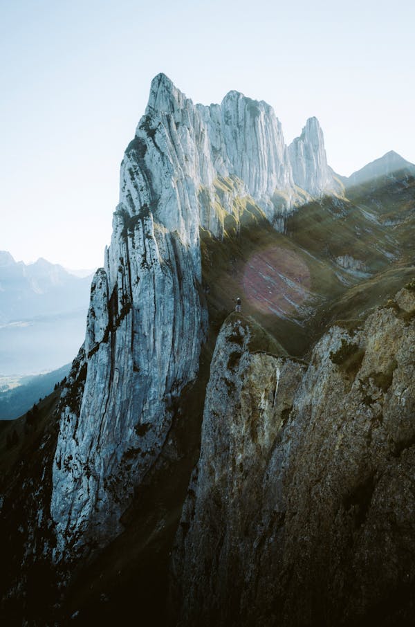 Photo of Person Standing on Cliff Edge