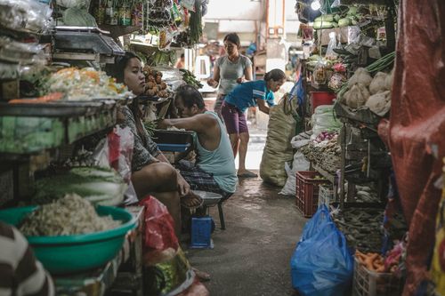 Free A vibrant local market scene with vendors selling diverse fresh produce and interacting with customers. Stock Photo