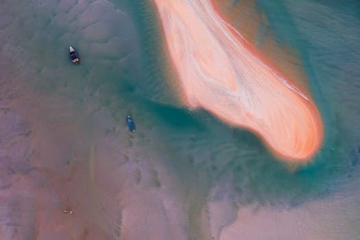 从高空俯瞰，沙洲被碧绿的海水和船只环绕，构成一幅宁静的海景