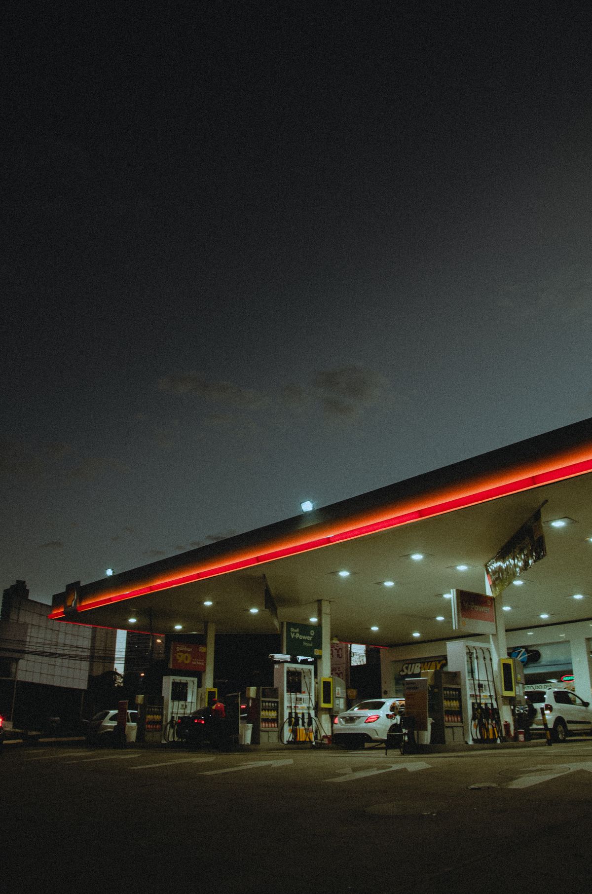 Love's Travel Stops: The Honest Guide to America's Favorite Road Trip Rest Stop 2 Fuel canopy at a highway travel stop glowing at dusk with vehicles refueling