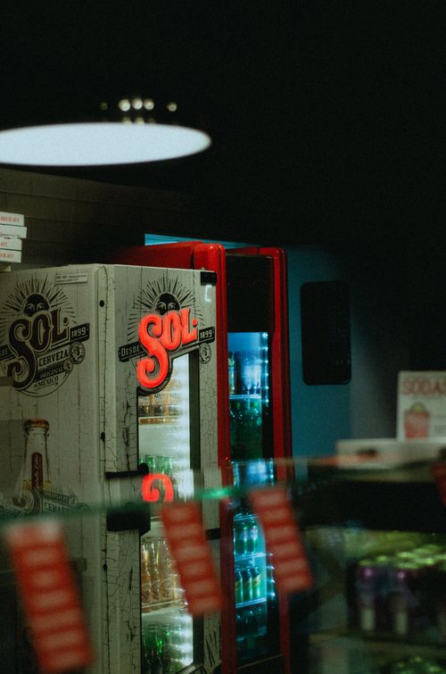 Free Dimly lit beverage cooler with branded drinks inside a store, providing a cool shopping ambiance. Stock Photo