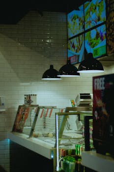 Interior of a modern restaurant featuring digital menu boards and pendant lighting.