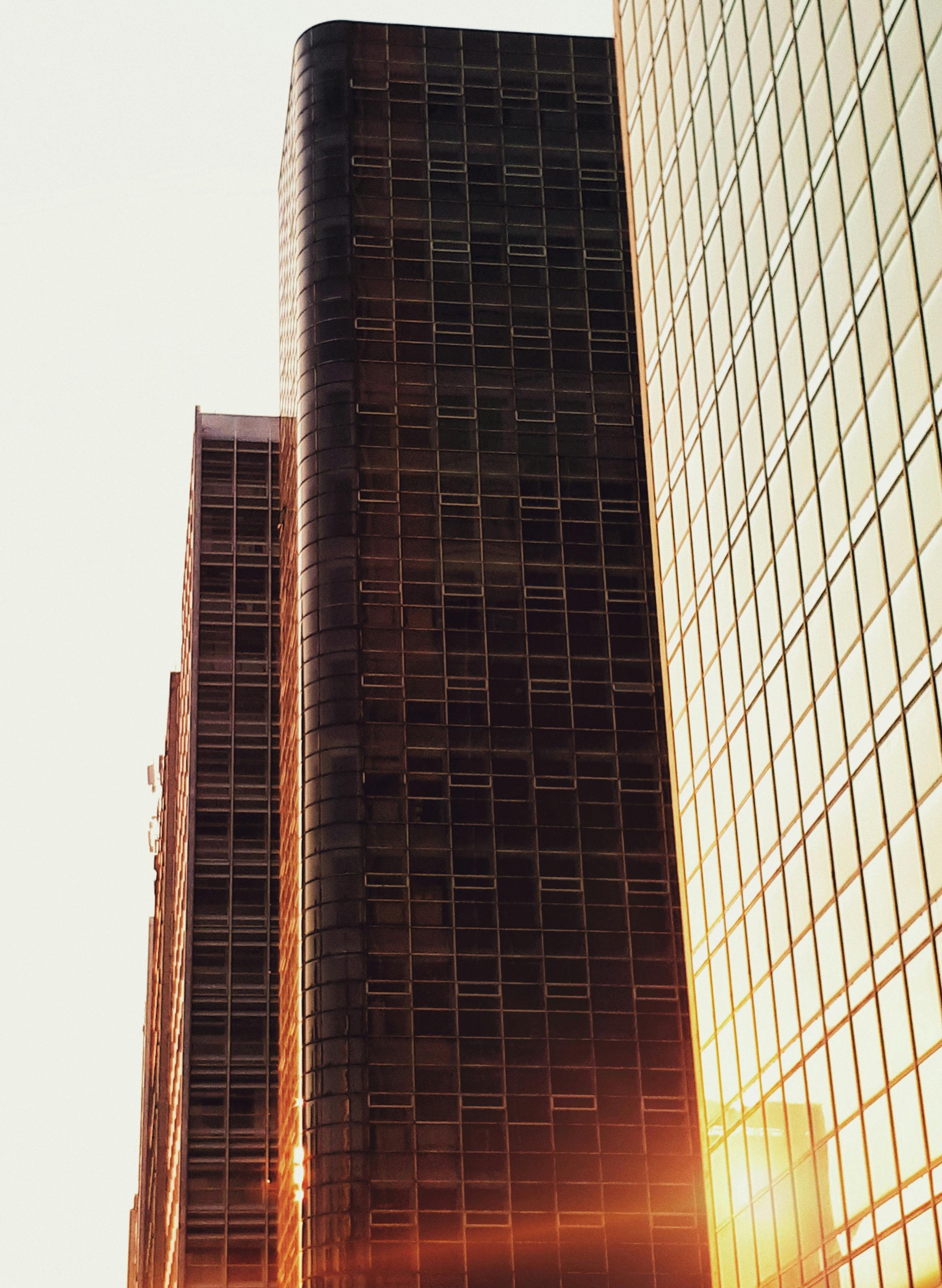 现代城市摩天大楼的外观被温暖的日落映照着