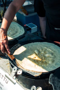 A vendor prepares traditional Finnish lettu at a lively street market in Lahti, Finland.