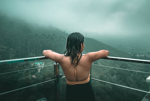 Free Woman Looking Out a Balcony Stock Photo