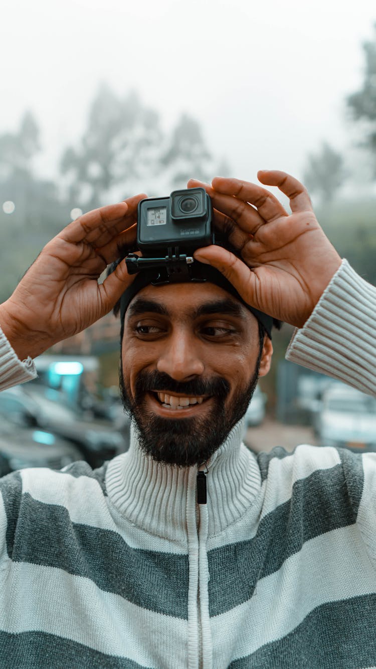 Person Holding Black Gopro Action Camera