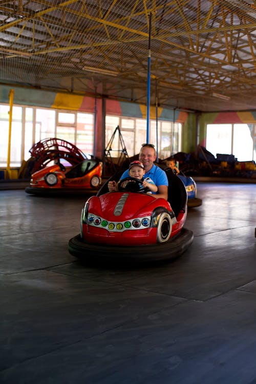 Father and Child Ride Bump Car at Amusement Park