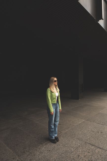 Fashionable woman with long hair and sunglasses standing in urban Montreal, QC.