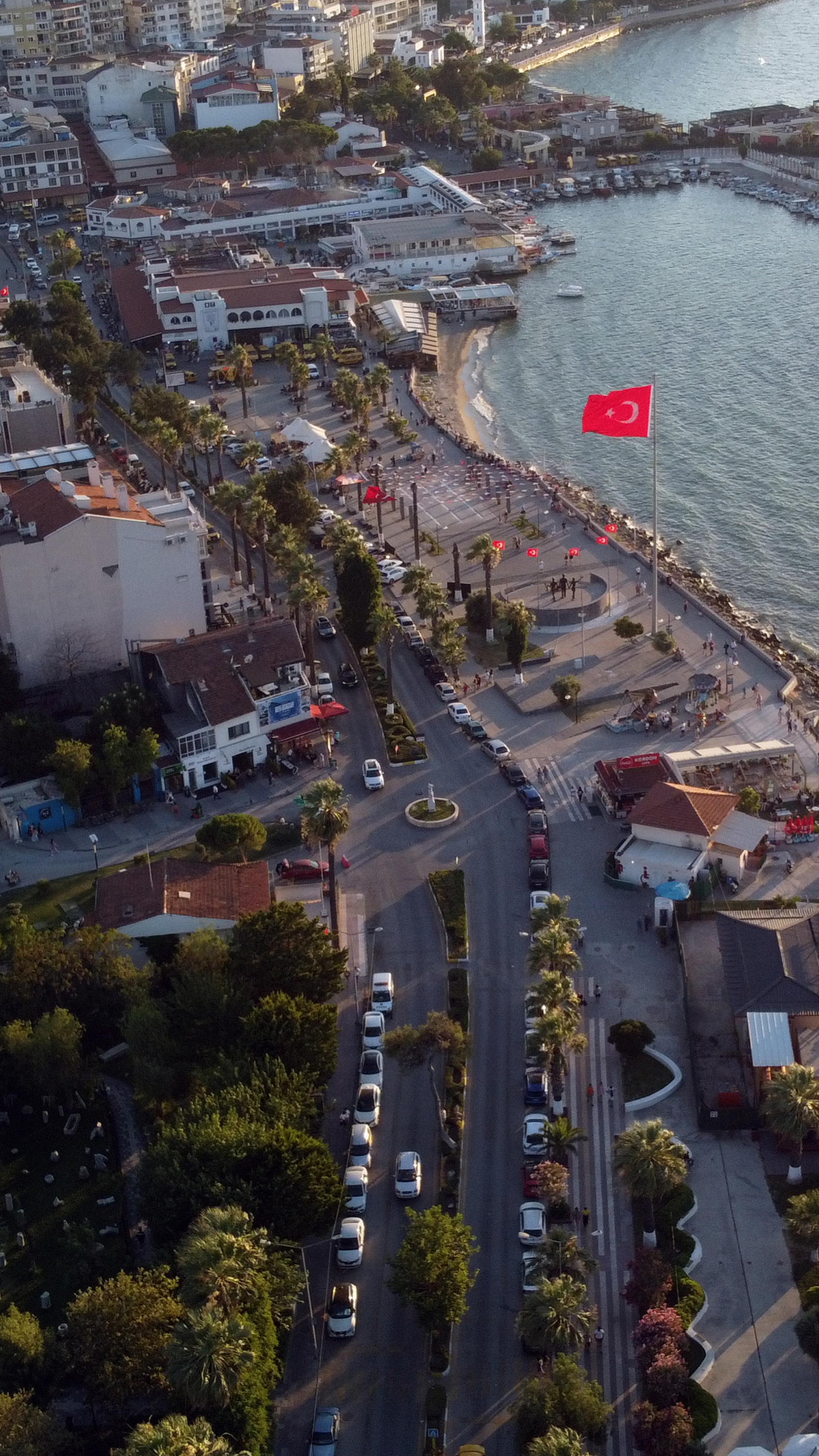Aerial view of Kuşadası waterfront in Türkiye, showcasing vibrant urban and coastal scene.