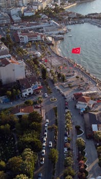 Aerial view of Kuşadası waterfront in Türkiye, showcasing vibrant urban and coastal scene.