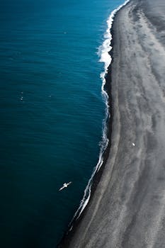 从空中俯瞰，冰岛偏远的海滩与充满活力的蓝色海洋融为一体，景象令人惊叹