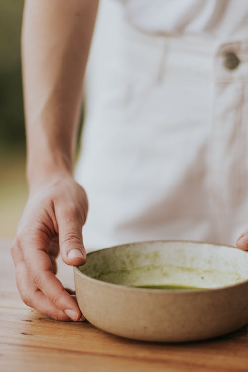 A person holding a bowl of green tea