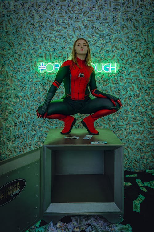 A woman in spider - man costume sitting on a box