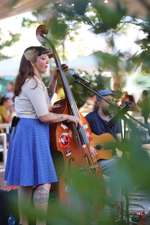 A woman playing a double bass in front of a crowd