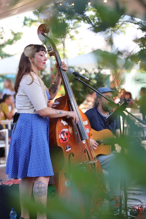 A woman playing a double bass in front of a crowd