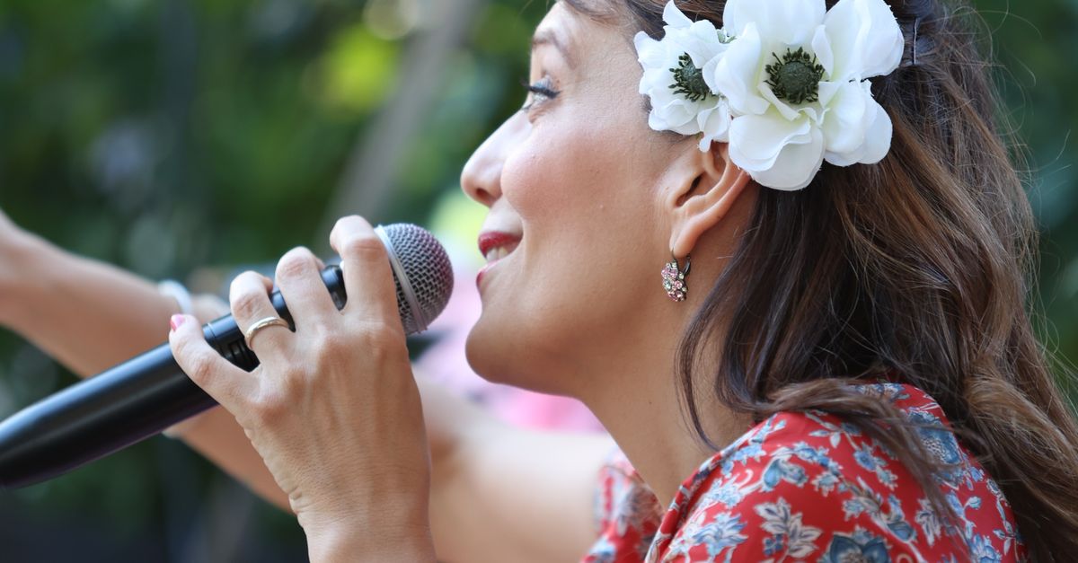 Singer with Microphone Waving to the Audience · Free Stock Photo