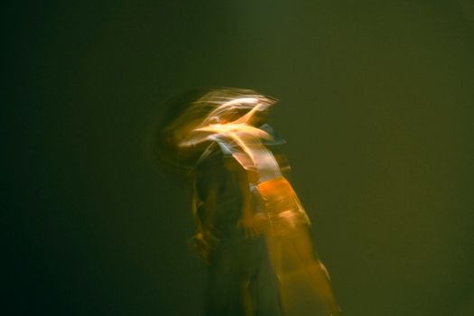Artistic abstract image of a human figure in motion with yellow light effects.