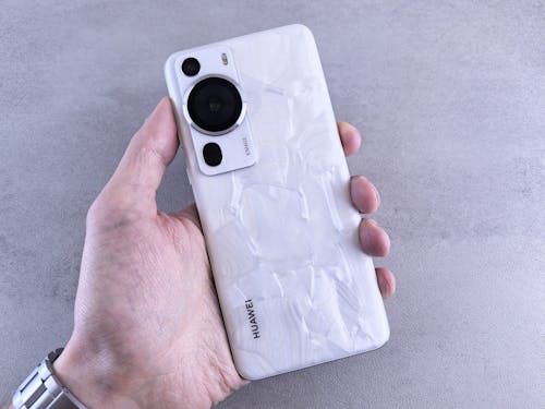 A person holding a white phone with a white case
