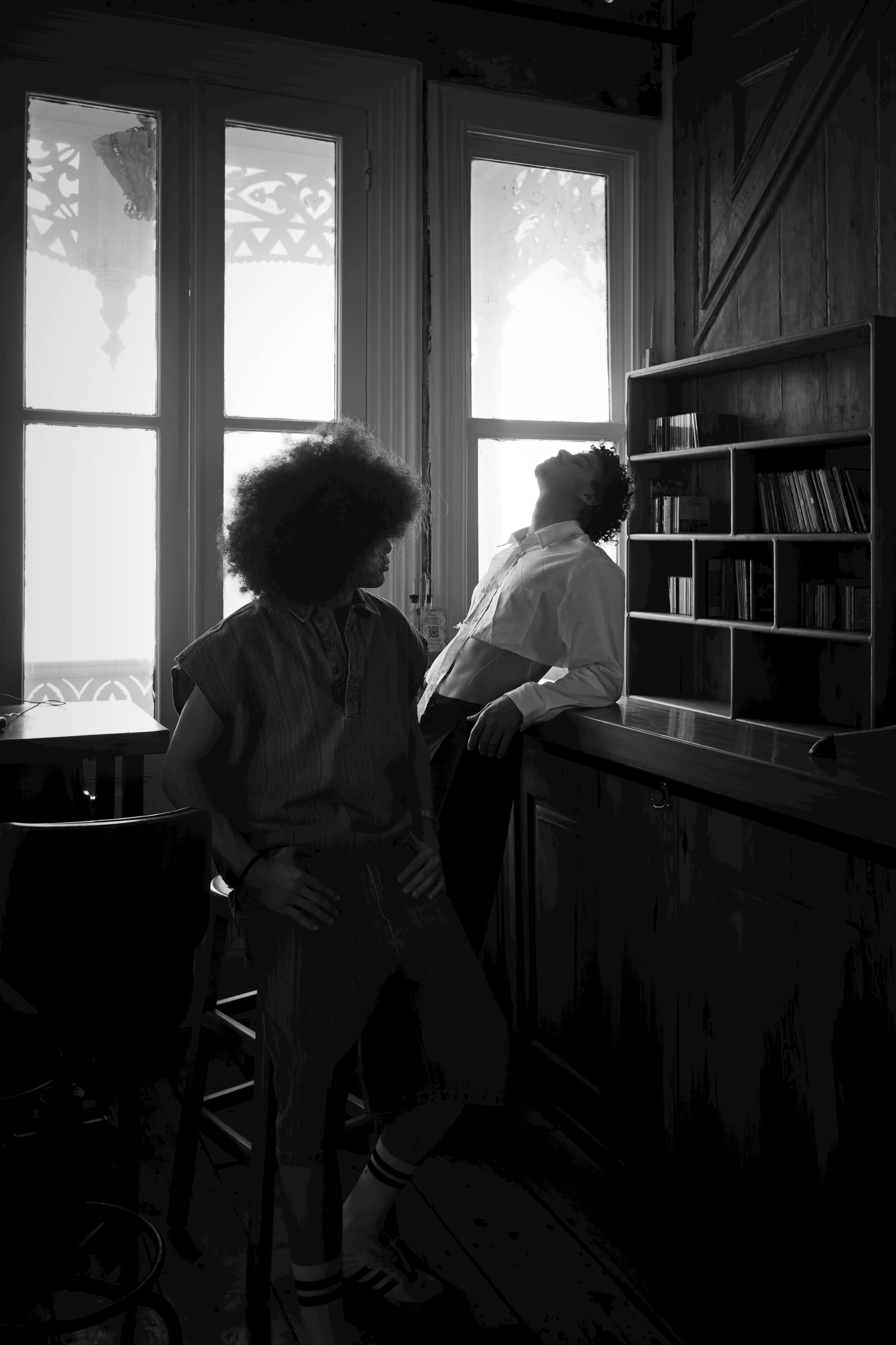 Stylish male and female models in a dramatic black and white indoor setting.