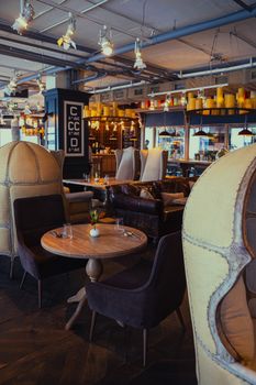 Elegant modern café interior with artistic lighting and unique chair designs, perfect for relaxation.