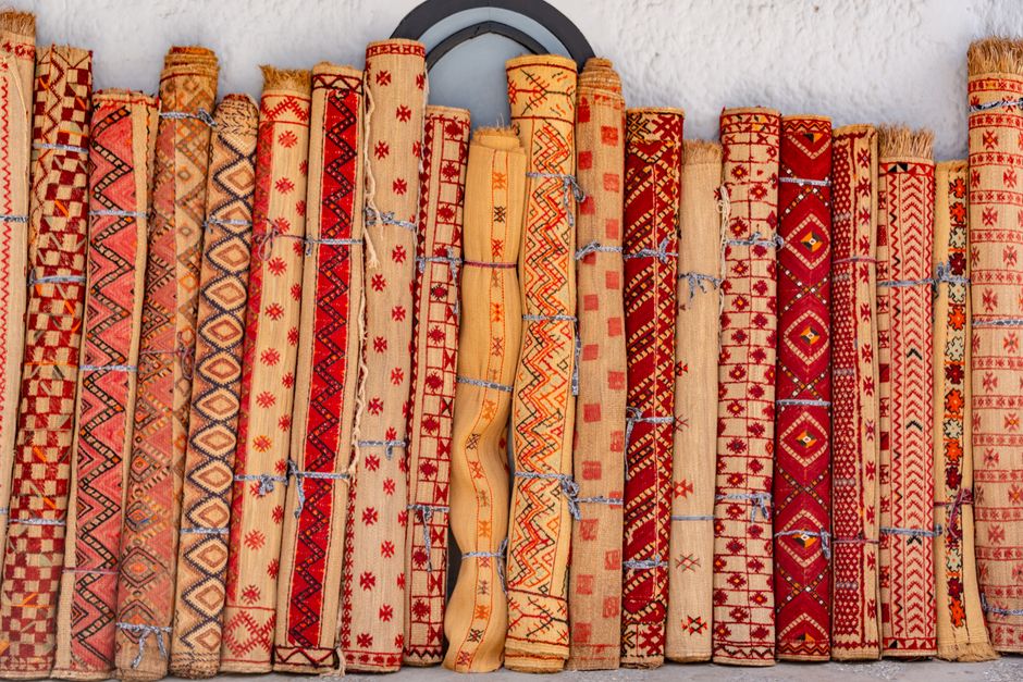 A vivid display of handmade traditional carpets with intricate patterns showing cultural craftsmanship.