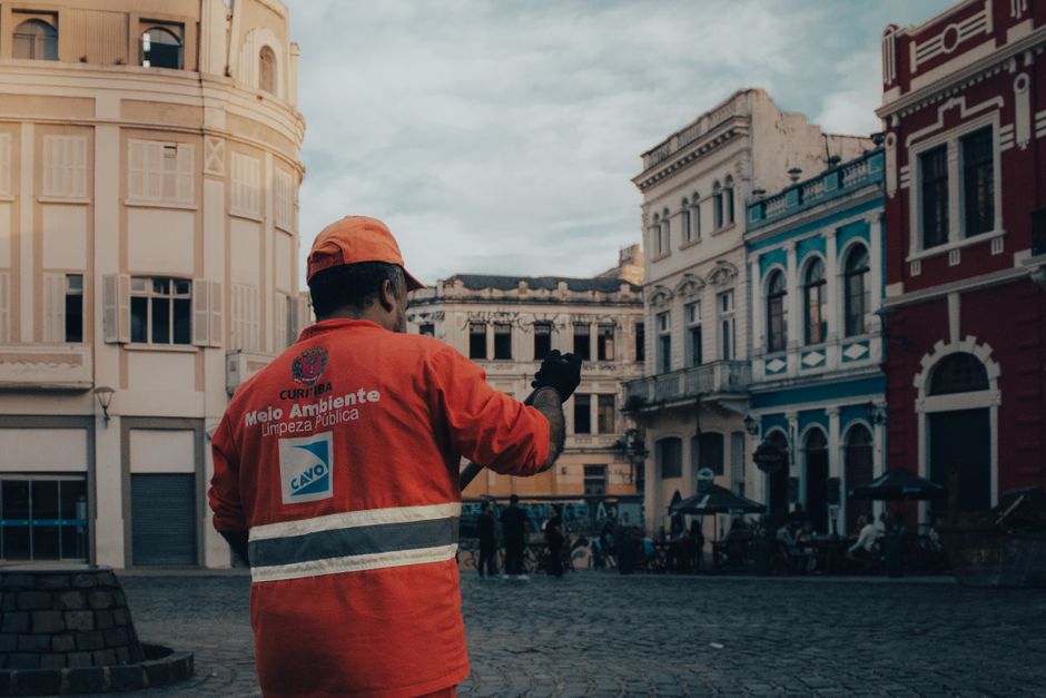 Un trabajador de la ciudad con un chaleco de alta visibilidad camina por el pintoresco casco antiguo de Curitiba, Brasil.