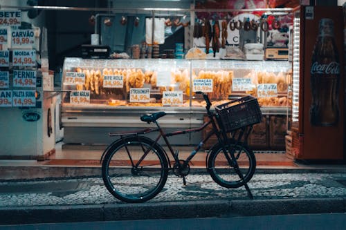 A bicycle parked in front of a bakery