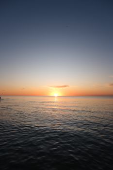 Serene ocean sunset view with gentle waves and vibrant colors across the horizon.