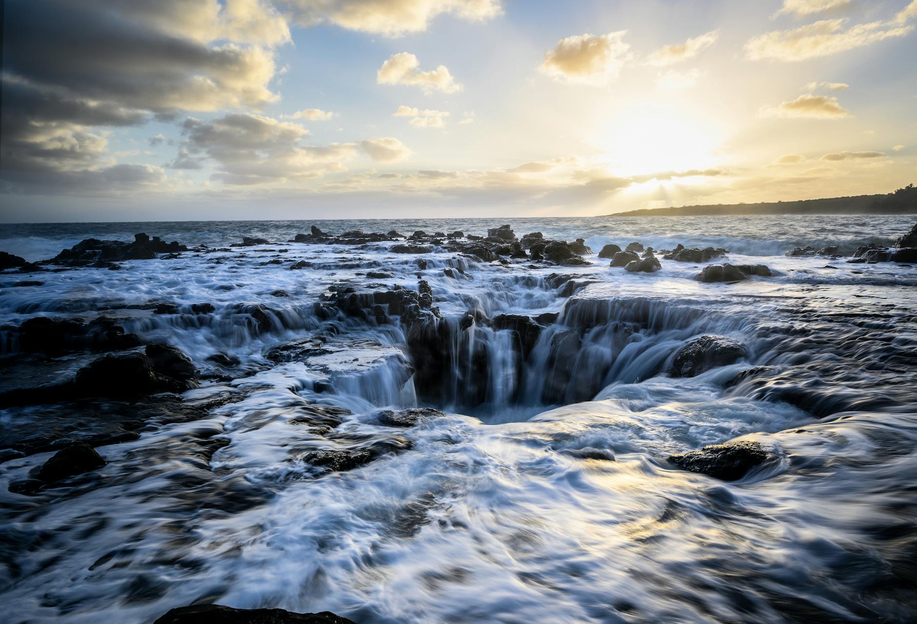 Photo by Matthew DeVries Stunning sunset illuminating turbulent ocean waters and rocky coastline of Kauai, Hawaii.