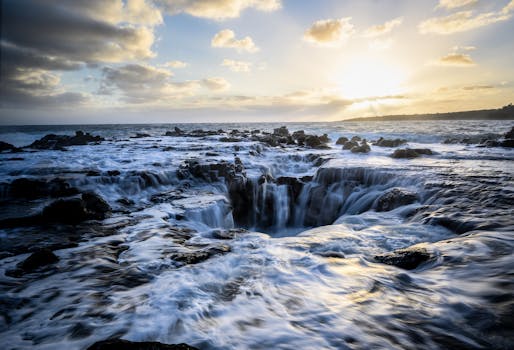 Stunning sunset illuminating turbulent ocean waters and rocky coastline of Kauai, Hawaii.
