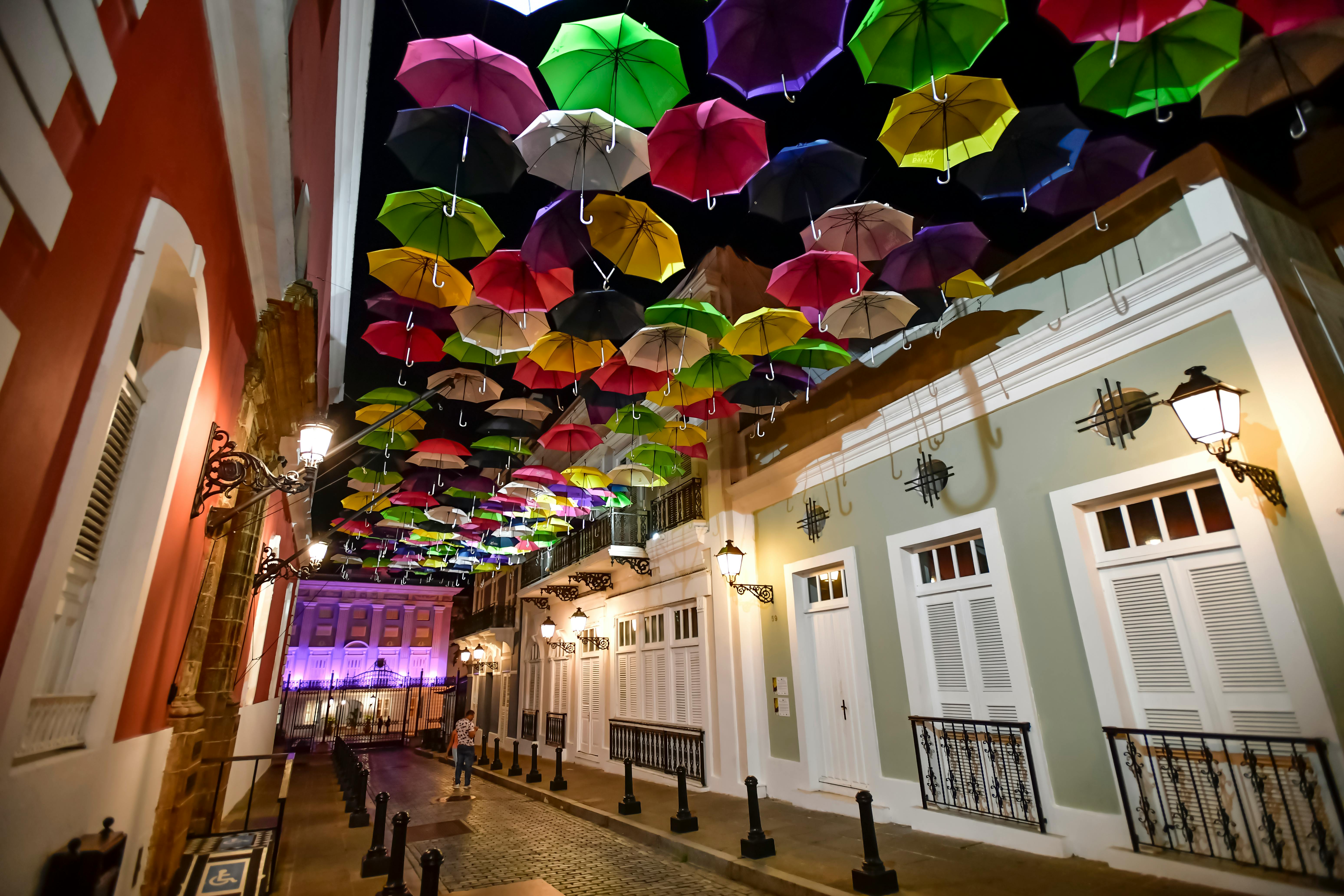 assorted coloured umbrellas hanging near buildings