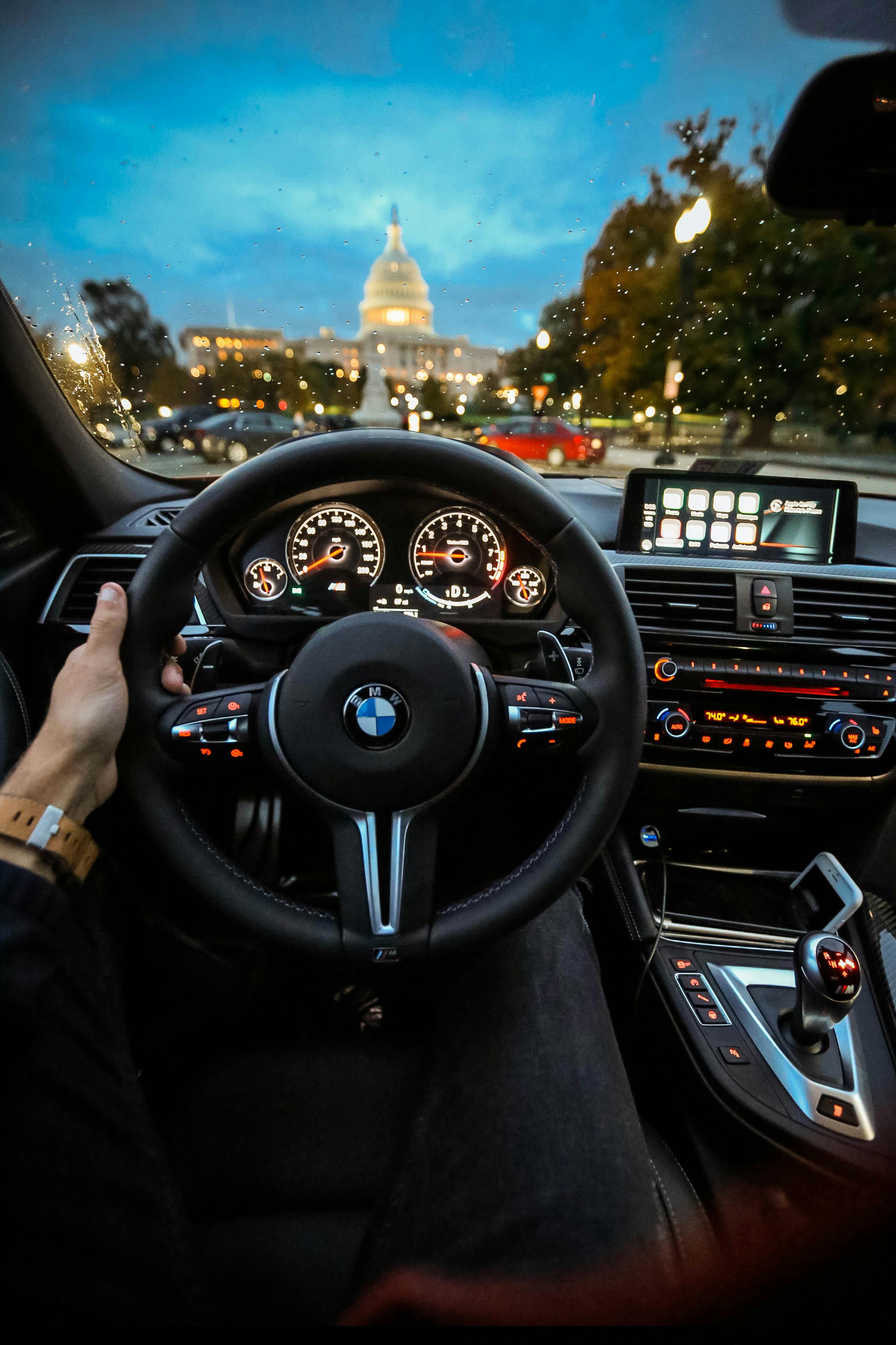 Person Holding Bmw Steering Wheel · Free Stock Photo