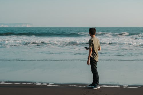 Photo of Man Standing on Seashore