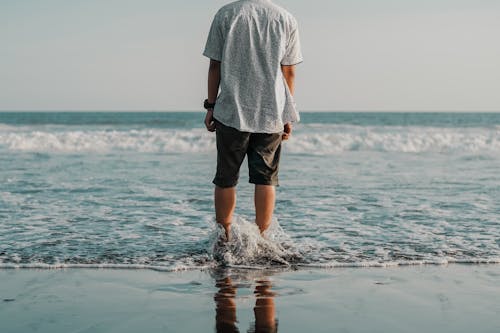 Photo of Person Standing on Seashore