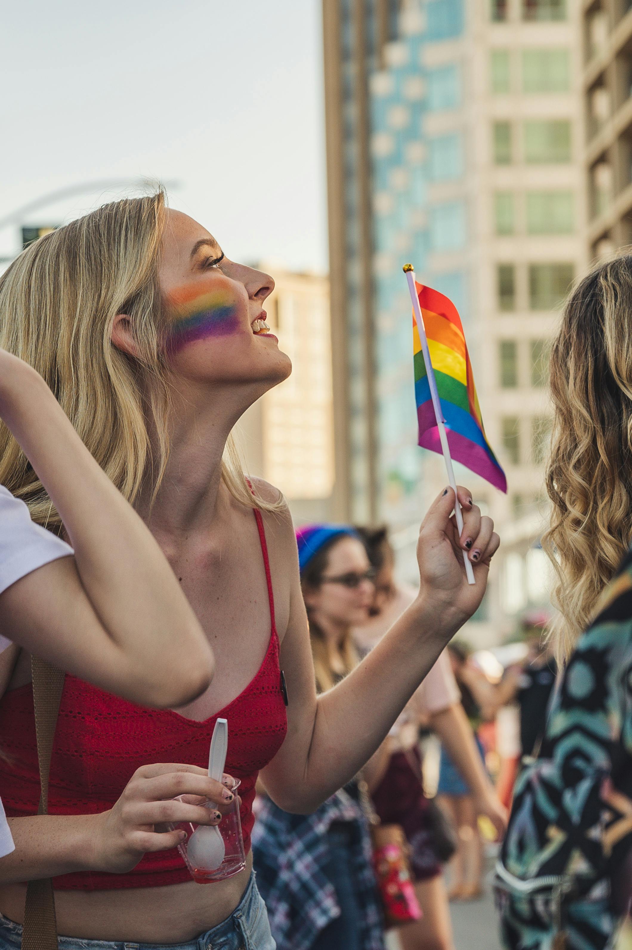 photo of woman holding rainbow flag