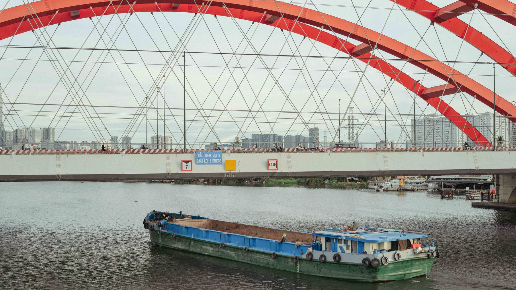 View of Binh Loi Bridge in Ho Chi Minh City with a barge on the Saigon River, Vietnam.