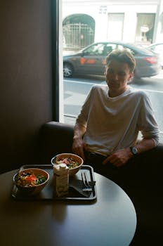 一名男子在现代餐厅里靠窗享用健康餐点