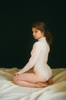 Striking portrait of a woman in a lace bodysuit at a studio photoshoot, showcasing elegance and style.